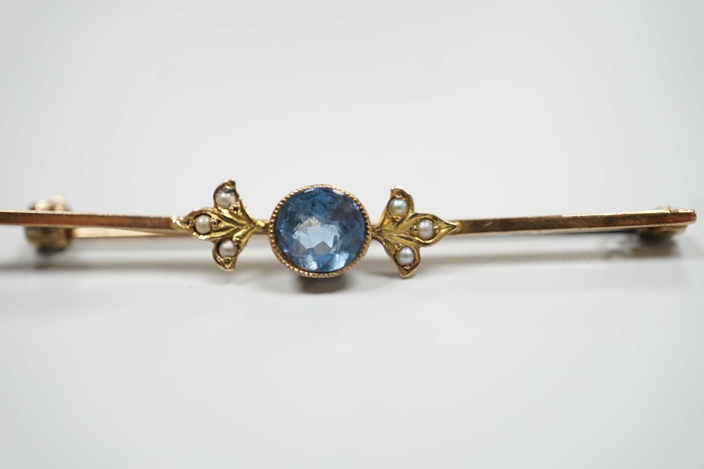 An Edwardian 9ct, aquamarine and seed pearl set bar brooch, 57mm, gross 3.6 grams.